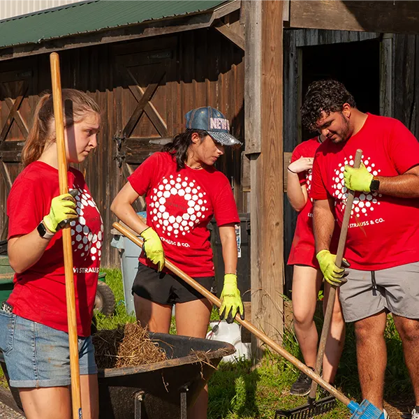 Volunteer in corporate tee shirts working around barn